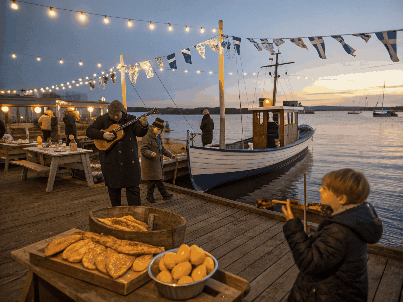 Traditional fishing boats moored in a historic Mediterranean harbour at dusk